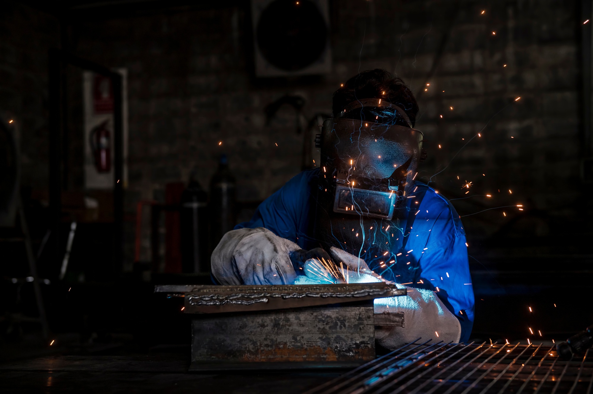 Men at work grinding steel